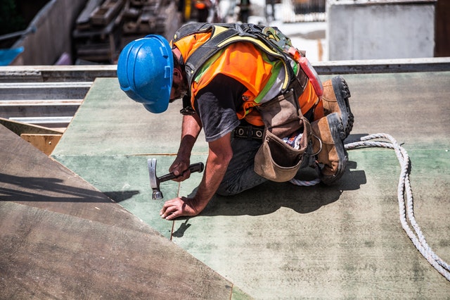 man on roof doing building works